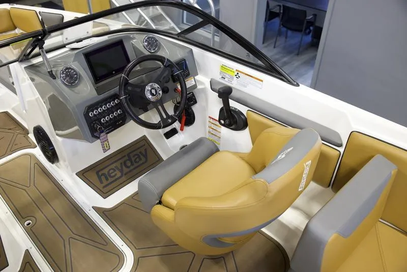 Slide: The Image of 2023 Heyday WTSurf boat interior with tan seats and modern dashboard controls. - 11