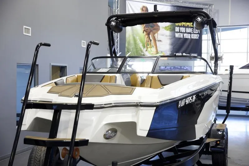Slide: The Image of 2023 Heyday WTSurf boat displayed indoors on a trailer. - 8