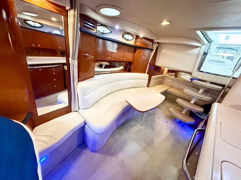 Slide: The Image of 2004 Sea Ray 340 Sundancer interior with elegant seating, wooden cabinetry, and ambient lighting. - 17