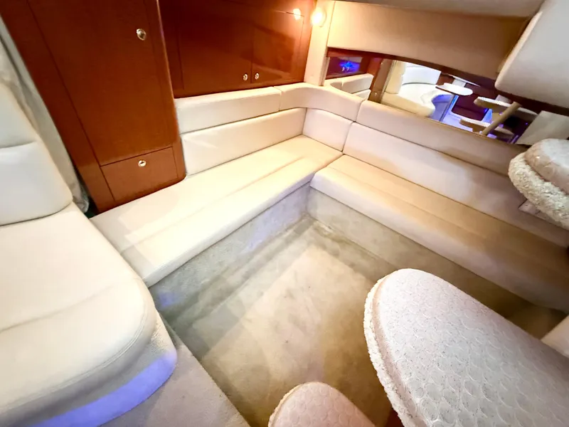 Slide: The Image of 2004 Sea Ray 340 Sundancer interior with beige seating and wooden cabinetry. - 19