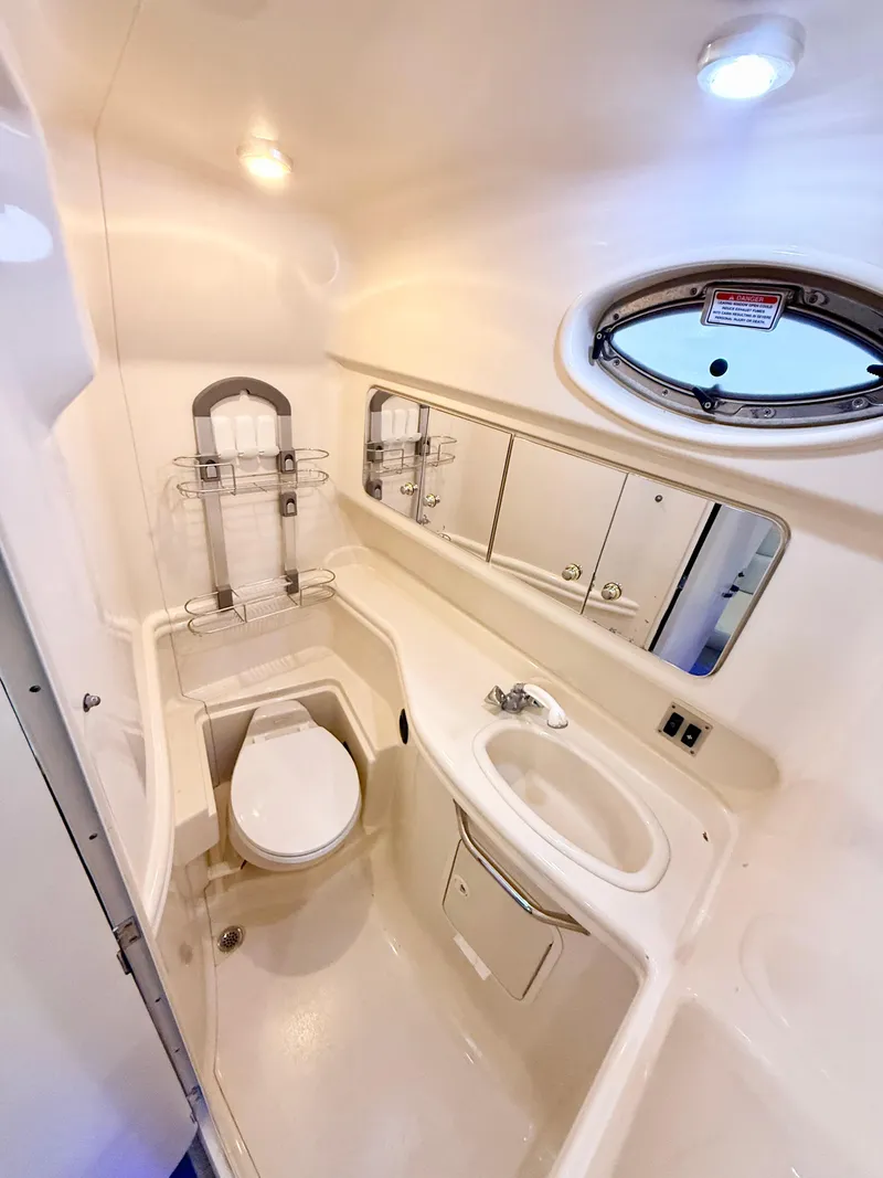 Slide: The Image of 2004 Sea Ray 340 Sundancer bathroom with sink, toilet, and porthole window. - 25