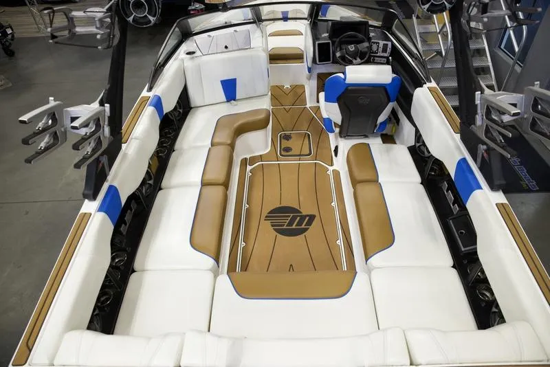Slide: The Image of 2024 Malibu 23 LSV boat interior with white, blue, and tan seating, featuring a sleek design. - 11