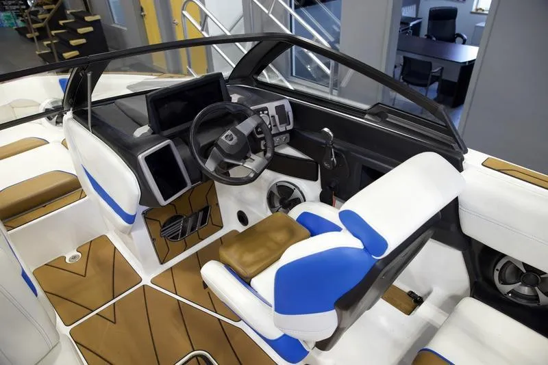Slide: The Image of 2024 Malibu 23 LSV boat interior with modern dashboard and blue-accented seating. - 13