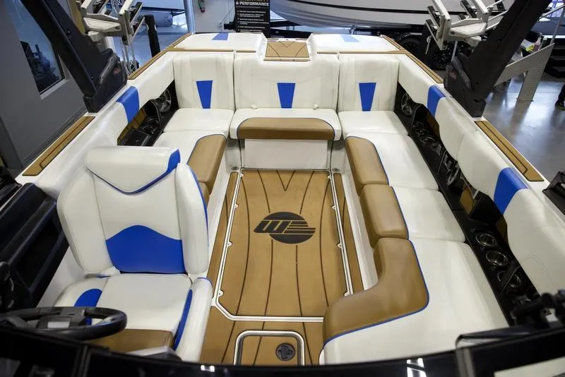 Slide: The Image of 2024 Malibu 23 LSV boat interior with white, blue, and tan seating. - 19