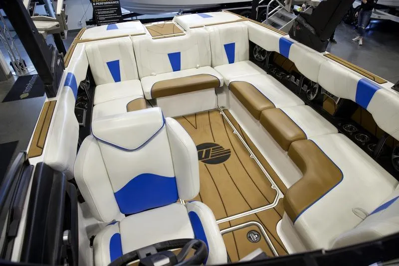 Slide: The Image of 2024 Malibu 23 LSV boat interior with white, blue, and brown seating. - 20