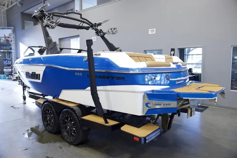 Slide: The Image of 2024 Malibu 23 LSV boat in showroom, blue and white design, on a trailer. - 6