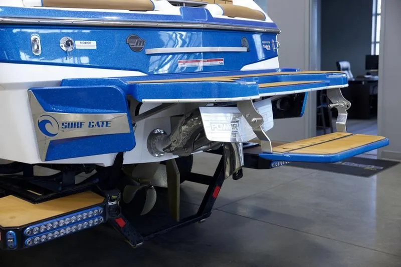 Slide: The Image of 2024 Malibu 23 LSV boat with Surf Gate technology, rear view in showroom. - 7