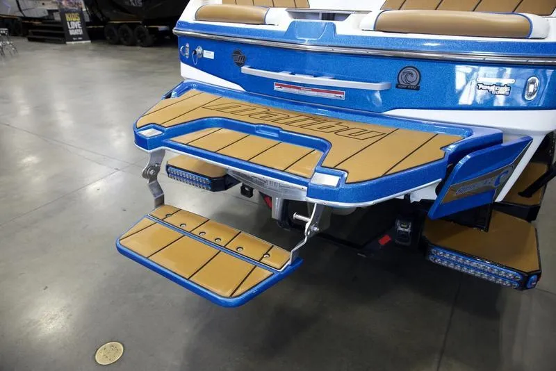 Slide: The Image of 2024 Malibu 23 LSV boat with blue and tan swim platform in showroom. - 8