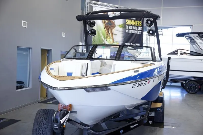 Slide: The Image of 2024 Malibu 23 LSV boat displayed indoors on a trailer. - 9