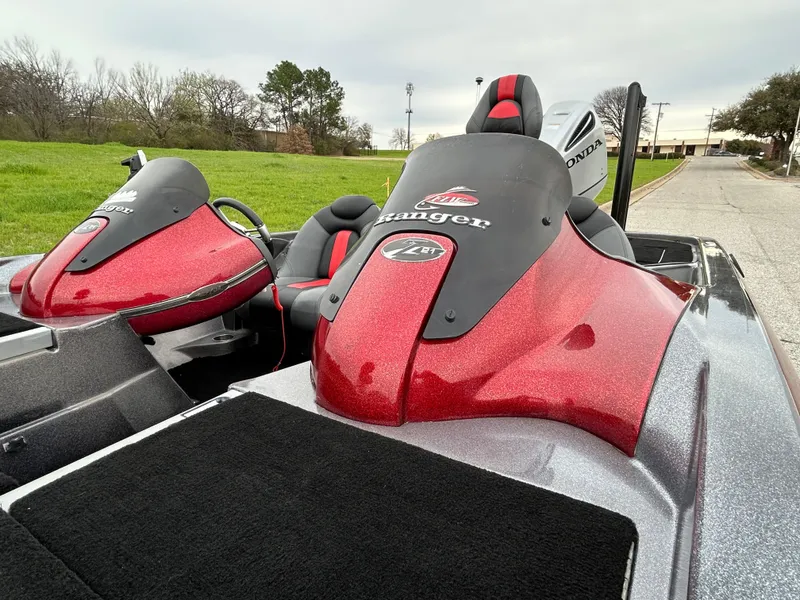 Slide: The Image of 2008 Ranger Z21 boat with red and black detailing, parked on a grassy roadside. - 11