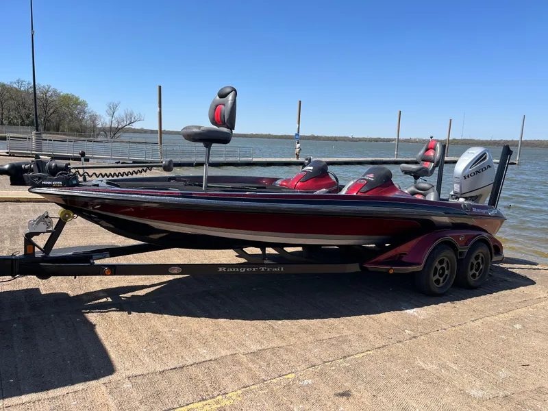 Slide: The Image of 2008 Ranger Z21 boat on trailer by a lake, featuring red and black design. - 12