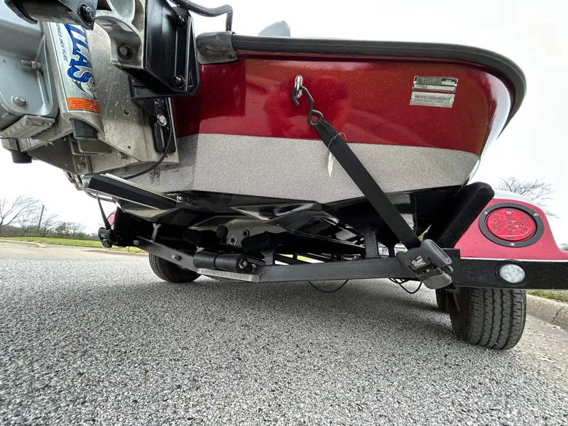 Slide: The Image of 2008 Ranger Z21 boat trailer, red and silver, parked on asphalt. - 13