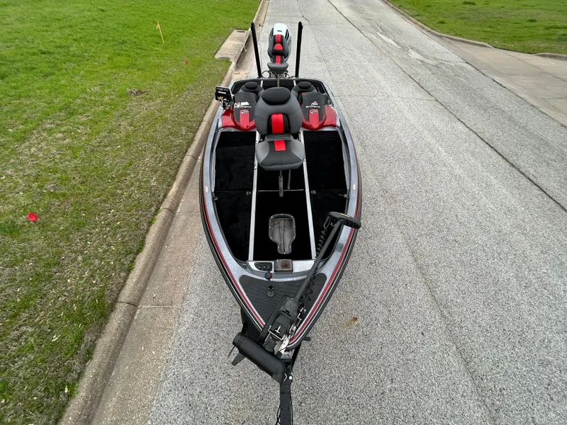Slide: The Image of 2008 Ranger Z21 boat on road, featuring red and black seating, parked on asphalt. - 20