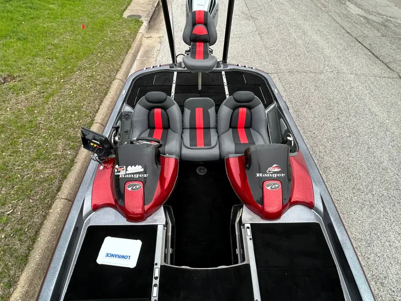 Slide: The Image of 2008 Ranger Z21 boat interior with red and black seats, parked on a street. - 30