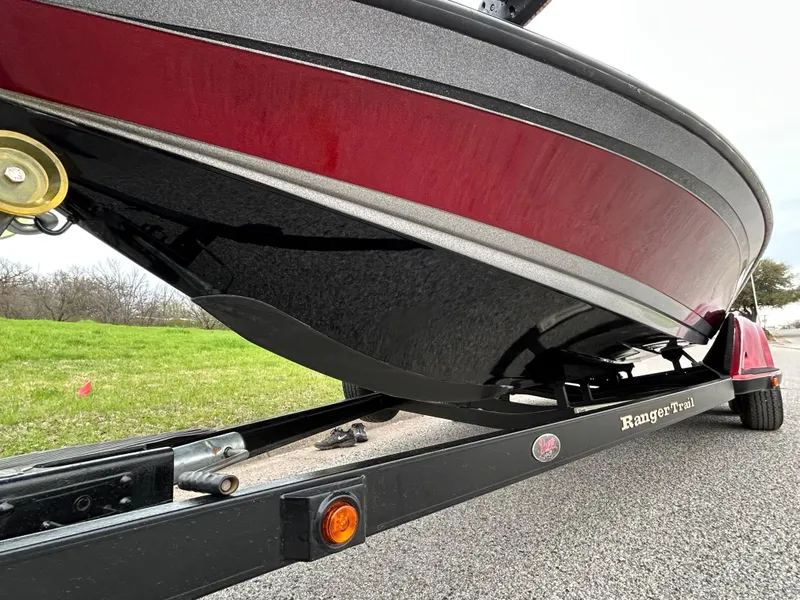 Slide: The Image of 2008 Ranger Z21 boat on trailer, red and black hull, parked on road. - 33