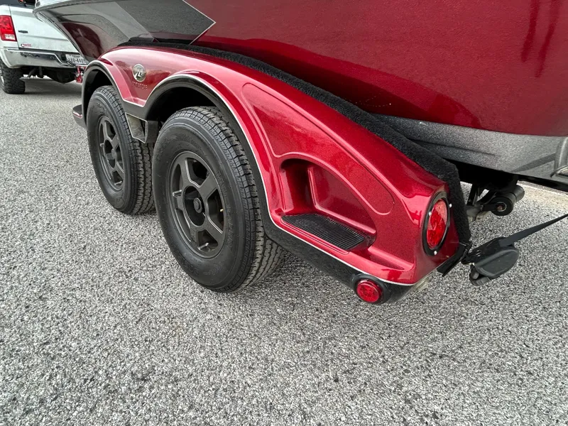 Slide: The Image of 2008 Ranger Z21 boat trailer with dual black wheels and red fender on asphalt. - 48