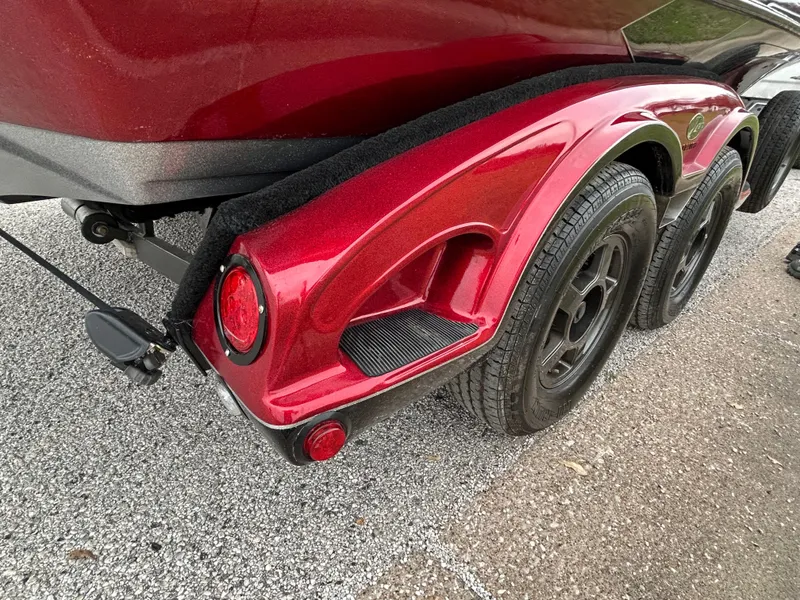 Slide: The Image of 2008 Ranger Z21 boat trailer with red fender and dual wheels on gravel. - 49