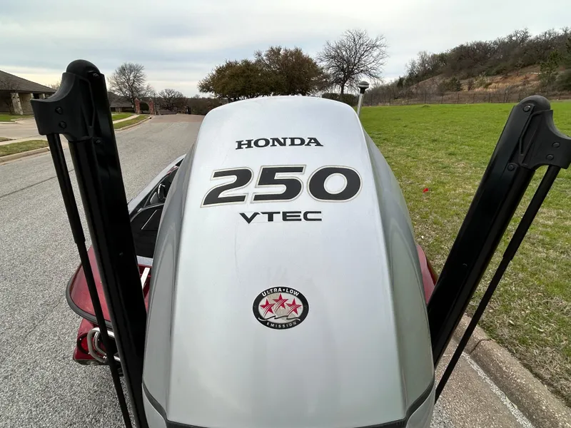 Slide: The Image of Honda 250 VTEC engine on a 2008 Ranger Z21 boat, parked on a suburban street. - 51