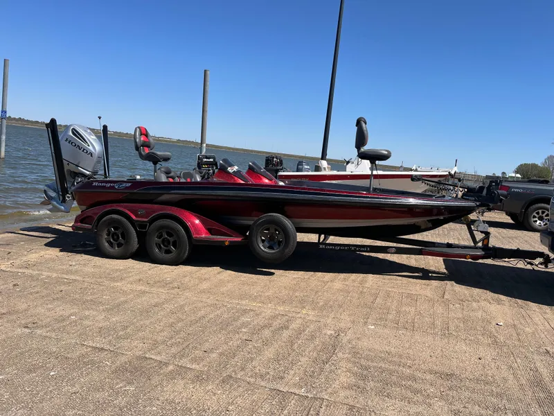 Slide: The Image of 2008 Ranger Z21 boat with Honda outboard motor on a trailer in a parking lot. - 7