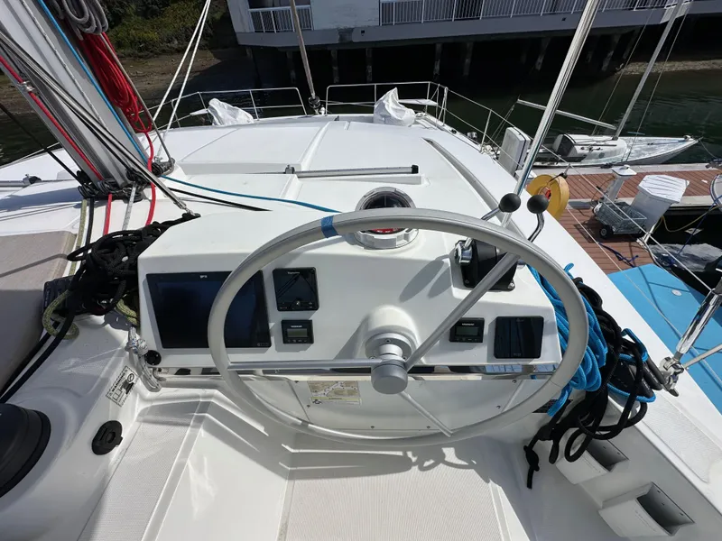 Slide: The Image of Steering wheel of 2023 Bali 4.2 yacht with navigation controls and dock view. - 14