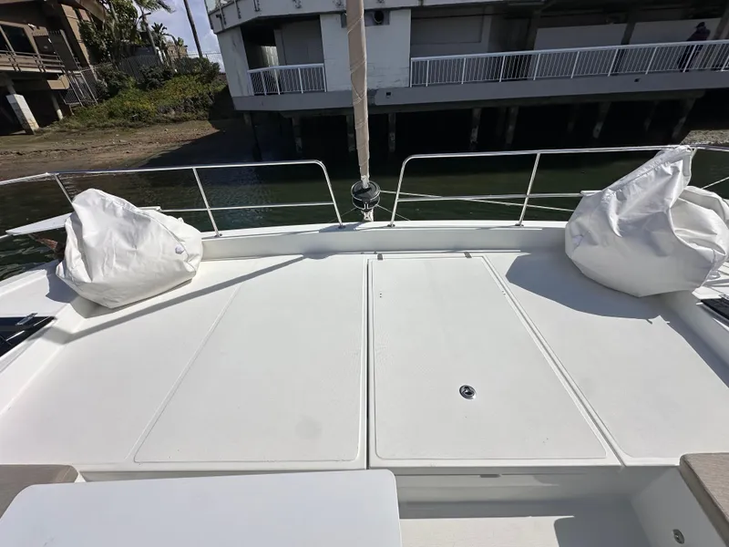 Slide: The Image of Deck of 2023 Bali 4.2 yacht with white cushions, docked near a building. - 26