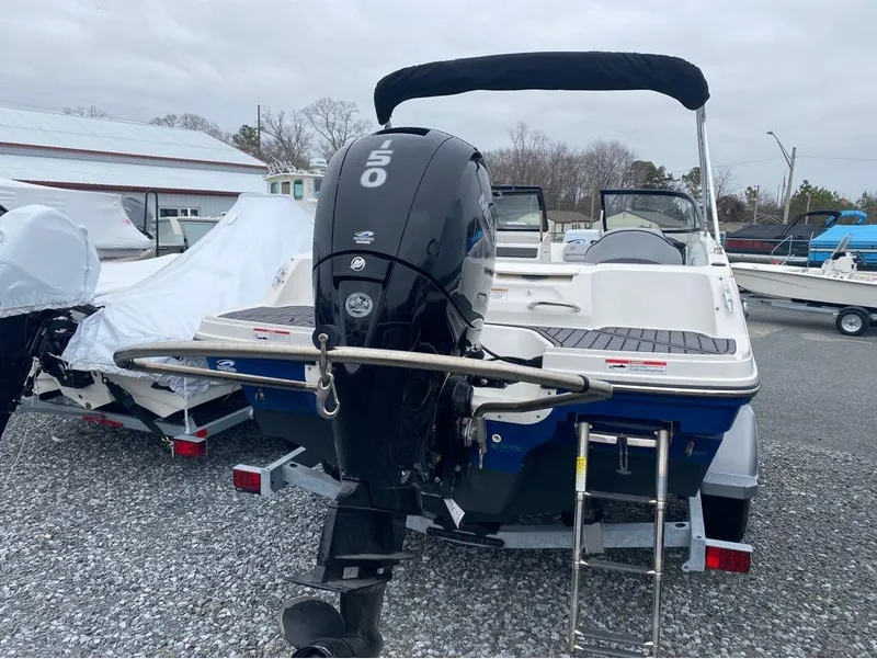 Slide: The Image of 2023 Bayliner VR4 Bowrider with outboard motor, parked on gravel lot. - 10