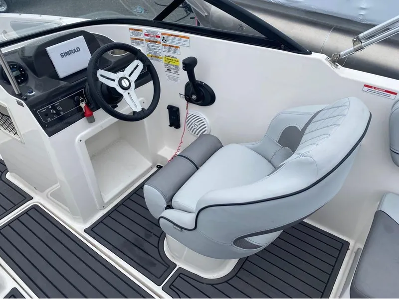 Slide: The Image of 2023 Bayliner VR4 Bowrider cockpit with steering wheel and cushioned seat. - 3