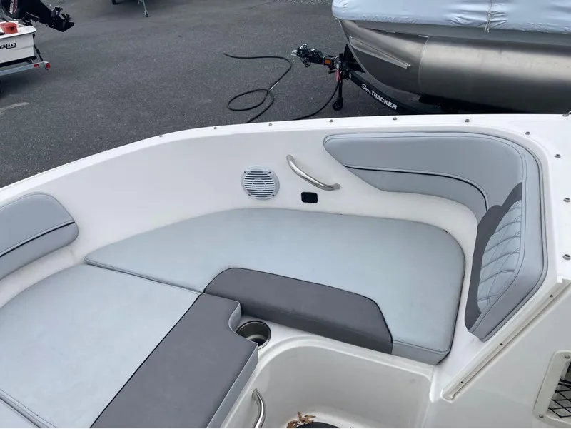 Slide: The Image of 2023 Bayliner VR4 Bowrider Outboard interior with gray seating and speaker. - 8