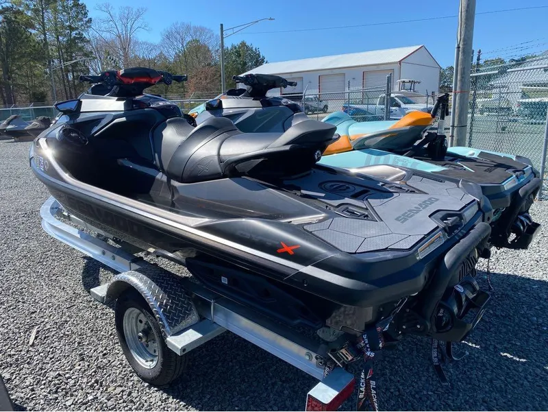 Slide: The Image of 2022 Sea-Doo RXT-X 300 jet skis on trailer, Triple Black/Wake Pro models. - 11