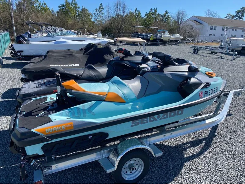 Slide: The Image of 2022 Sea-Doo RXT-X 300 and Wake Pro jet skis on trailer, parked outdoors. - 9