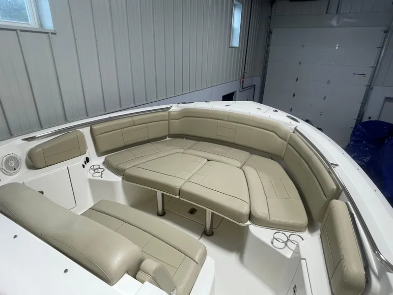 Slide: The Image of 2019 Pursuit S 328 Sport boat interior with beige seating in a garage. - 11