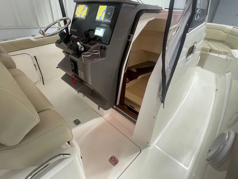 Slide: The Image of 2019 Pursuit S 328 Sport boat interior with helm, navigation screens, and seating area. - 14