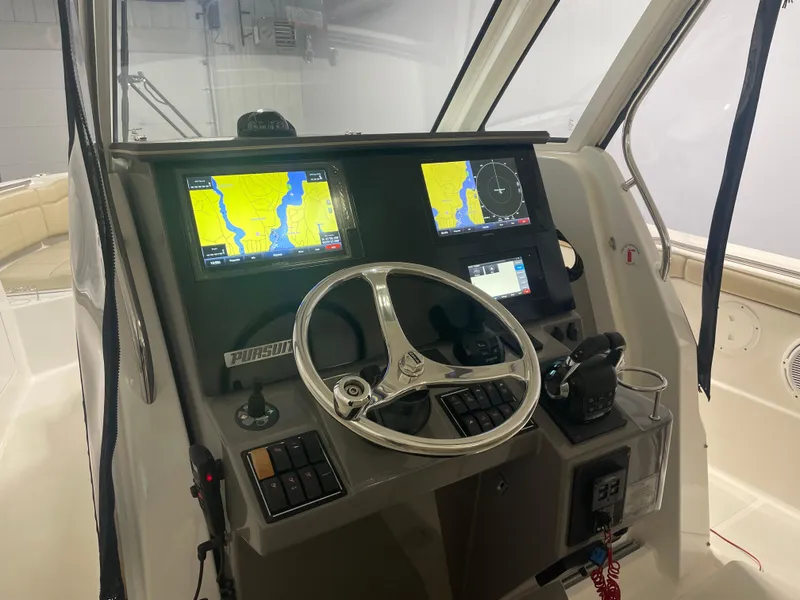 Slide: The Image of 2019 Pursuit S 328 Sport boat dashboard with navigation screens and steering wheel. - 17
