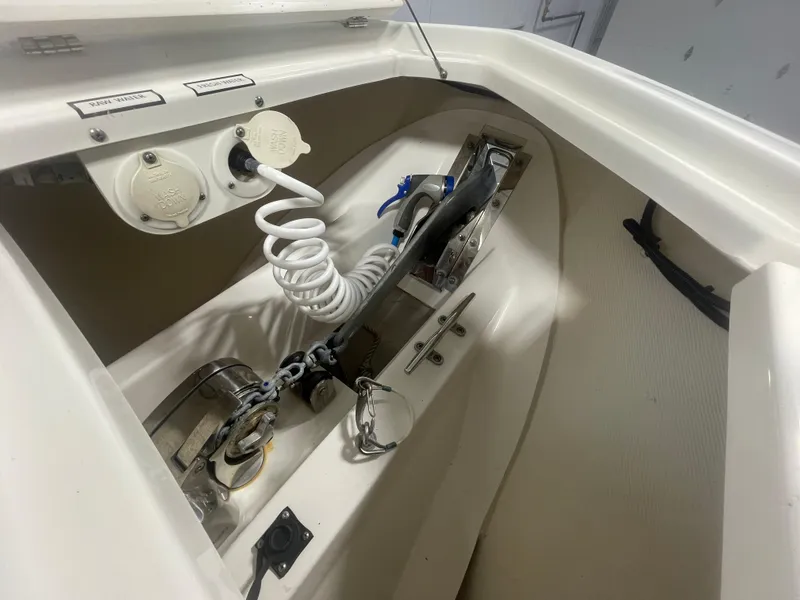 Slide: The Image of 2019 Pursuit S 328 Sport boat anchor compartment with washdown hose and chain. - 18