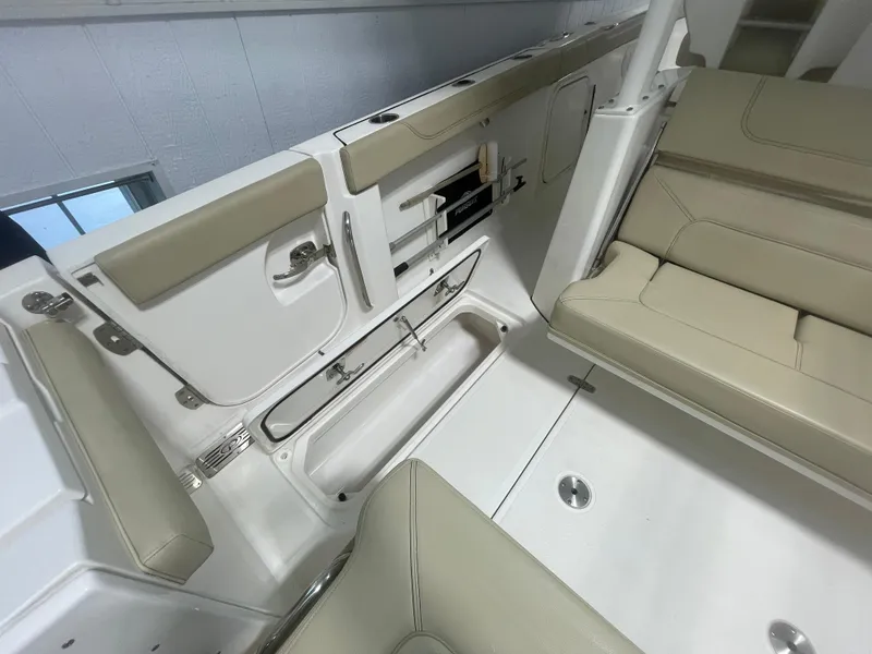 Slide: The Image of 2019 Pursuit S 328 Sport boat interior with beige seating and storage compartments. - 19