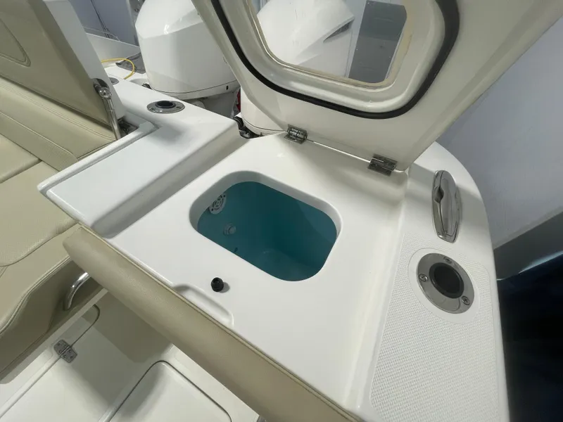 Slide: The Image of 2019 Pursuit S 328 Sport boat interior with open storage compartment and seating. - 20