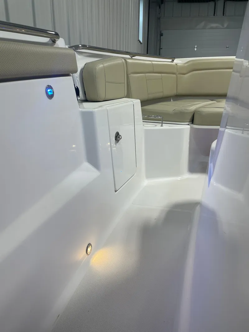 Slide: The Image of 2019 Pursuit S 328 Sport boat interior with beige seating and sleek white surfaces. - 22