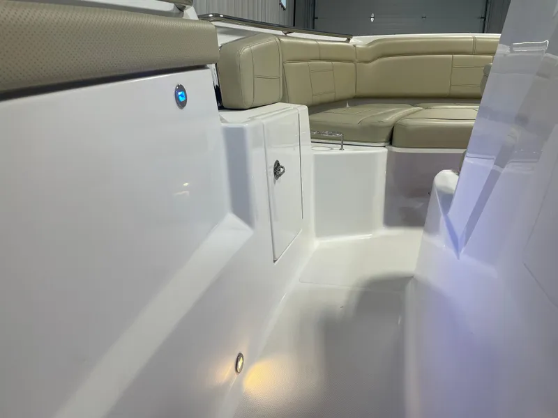 Slide: The Image of 2019 Pursuit S 328 Sport boat interior with beige seating and sleek white surfaces. - 23
