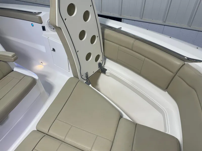 Slide: The Image of 2019 Pursuit S 328 Sport boat interior with beige seating and storage compartment. - 25