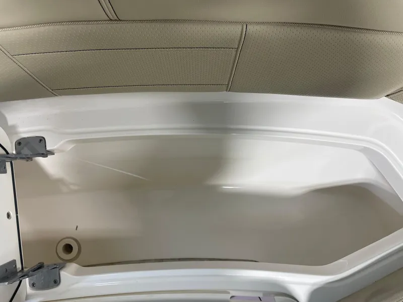 Slide: The Image of 2019 Pursuit S 328 Sport boat storage compartment with beige interior and metal hinges. - 26