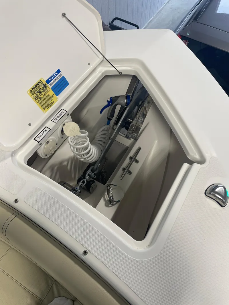 Slide: The Image of 2019 Pursuit S 328 Sport boat anchor compartment with coiled hose and chain. - 28