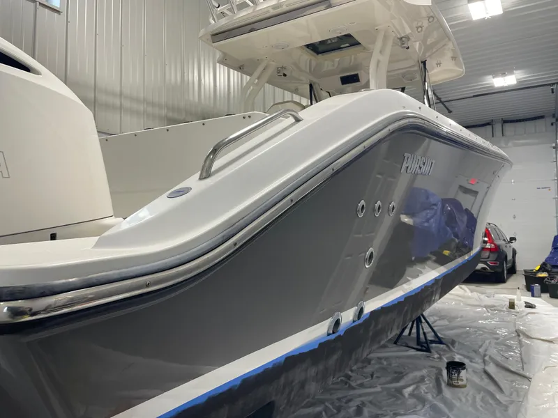 Slide: The Image of 2019 Pursuit S 328 Sport boat in a garage, side view, under maintenance. - 3