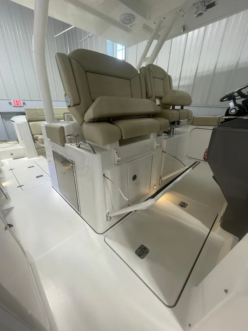 Slide: The Image of 2019 Pursuit S 328 Sport boat interior with beige seating and storage compartments. - 31