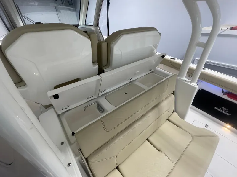 Slide: The Image of 2019 Pursuit S 328 Sport boat interior with beige seating and storage compartments. - 32