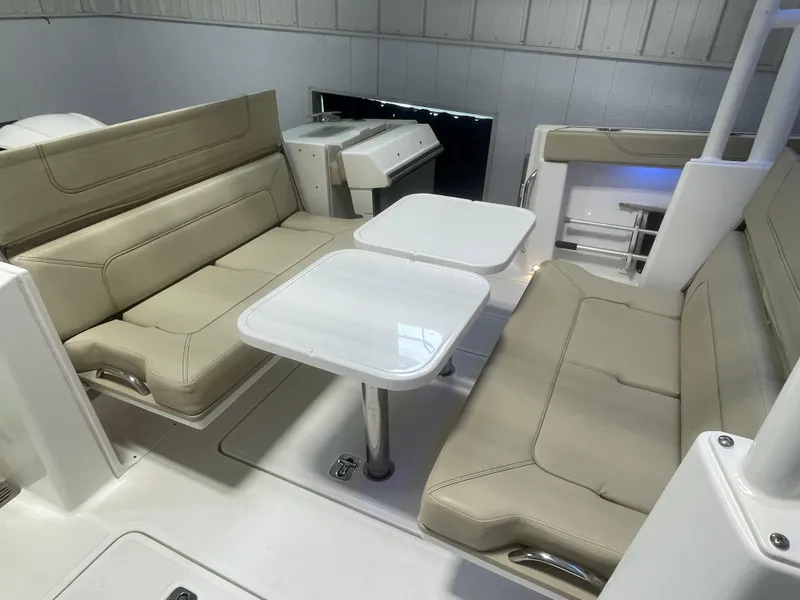 Slide: The Image of 2019 Pursuit S 328 Sport boat interior with beige seating and dual tables. - 33
