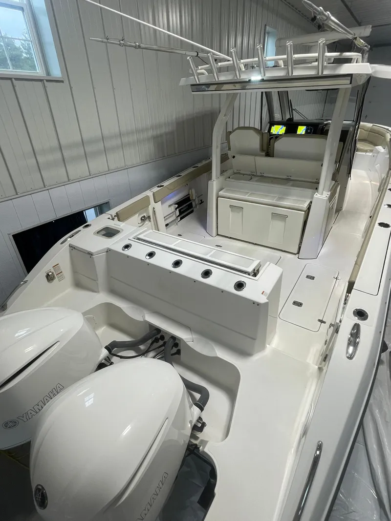 Slide: The Image of 2019 Pursuit S 328 Sport boat interior with Yamaha engines in a storage facility. - 41