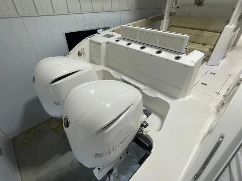 Slide: The Image of 2019 Pursuit S 328 Sport boat with dual Yamaha outboard engines in a garage. - 43
