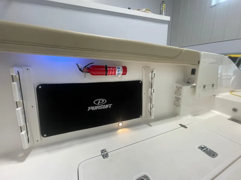 Slide: The Image of 2019 Pursuit S 328 Sport boat interior with fire extinguisher and storage compartments. - 45