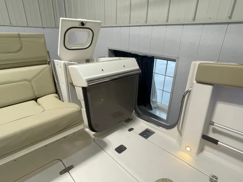 Slide: The Image of 2019 Pursuit S 328 Sport boat interior with beige seating and storage compartment. - 46