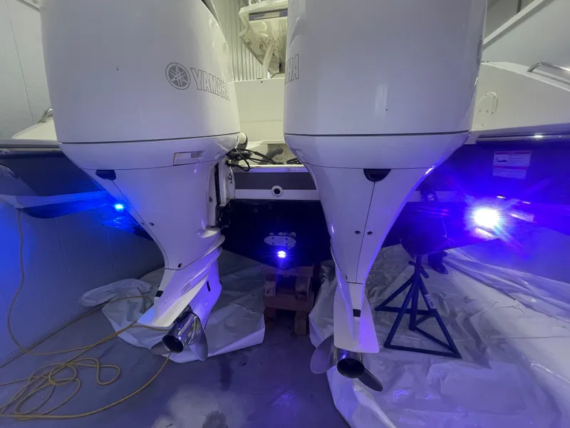 Slide: The Image of 2019 Pursuit S 328 Sport boat with dual Yamaha outboard engines, illuminated by blue lights. - 47